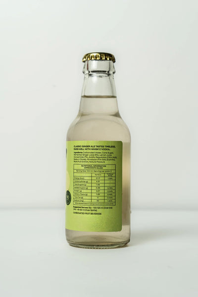 A clear glass bottle of Burp! Classic Ginger Ale with a light green back label and a gold crown cap, photographed against a plain white background.