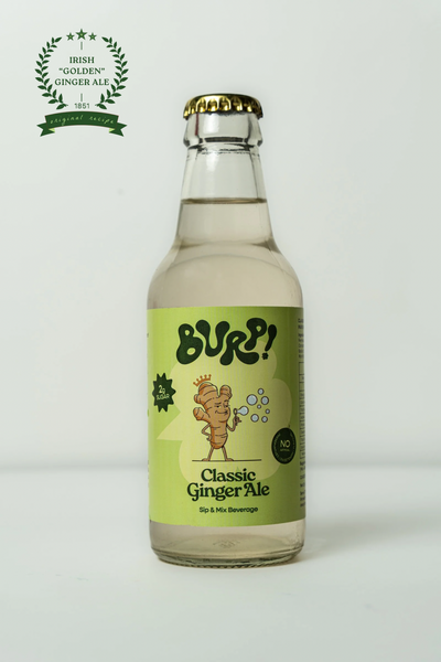 A bottle of BURP! Classic Ginger Ale on a light gray background, featuring a light green label with a cartoon ginger root character and a gold crown cap.